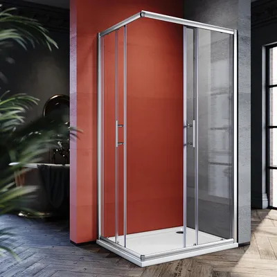 A modern bathroom with a red accent wall, featuring a glass shower enclosure.