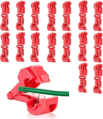 A collection of red wire connectors and one connector with a green wire inserted.