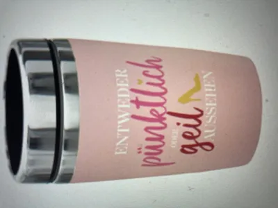A pink travel mug with text and a graphic.
