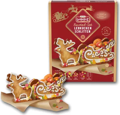 A box of Lambertz Lebkuchen Schlitten Bastel Set with two decorated gingerbread sleds and reindeer in the foreground.