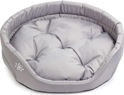 A gray oval dog bed with a tufted cushion and a small white flower embroidered on the side.