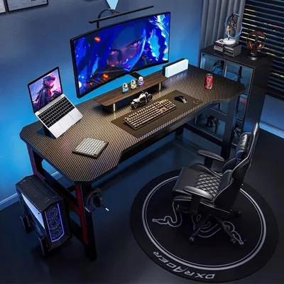 A gaming desk setup with a computer, monitor, laptop, and chair.