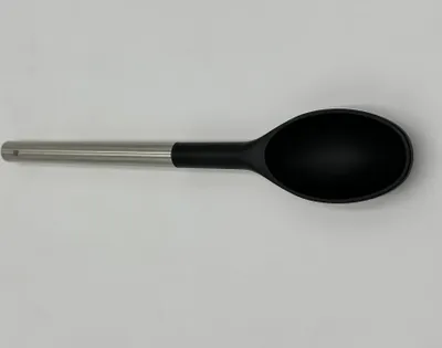 A single black and silver spoon is laid horizontally on a plain white background.