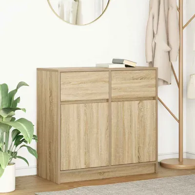 A wooden sideboard with two drawers and two doors, placed in a room with a plant and a coat rack.