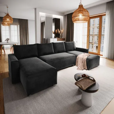 A modern living room with a large sectional sofa, coffee table, and decorative elements.