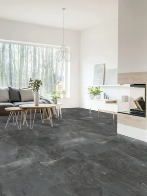 A modern living room with a large window, sofa, coffee table, and fireplace, showcasing the flooring.
