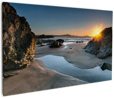 Produktbild von Wallario Premium Leinwandbild Sonnenuntergang hinter einem Felsen am Strand in Größe 60 x 90 cm