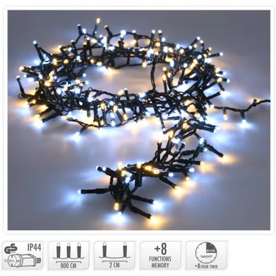 A string of microcluster Christmas lights with both warm white and white LEDs, coiled on a light gray surface.