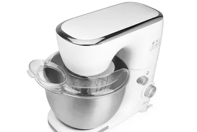 A white kitchen mixer with a silver bowl and attachments, shown against a white background.