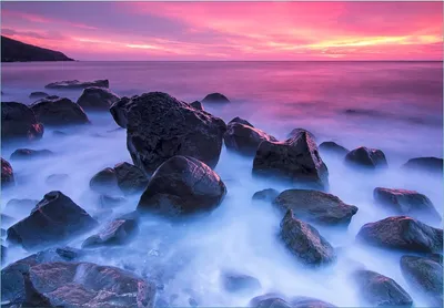 Produktbild von Wallario Fototapete Vliestapete, seidenmatte Oberfläche, einfache Verarbeitung, Größe 300 x 210 cm, Motiv Felsen im Meer bei Sonnenuntergang