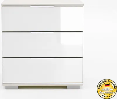 A white three-drawer nightstand with a glossy finish, shown against a white background. A circular badge indicating 'Premium-Qualität made in Germany' is visible in the bottom right corner.