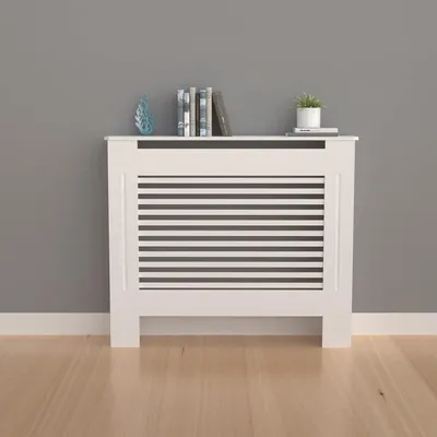 A white radiator cover with horizontal slats is placed against a gray wall and on a light wood floor.