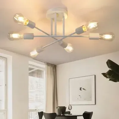 A modern white chandelier with six bulbs hangs from the ceiling in a dining room setting.