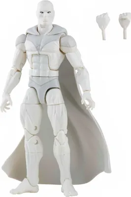 A white action figure of the character Vision, with a grey cape and grey accents on the suit, is shown standing against a white background. Two interchangeable hands are placed to the upper right of the figure.
