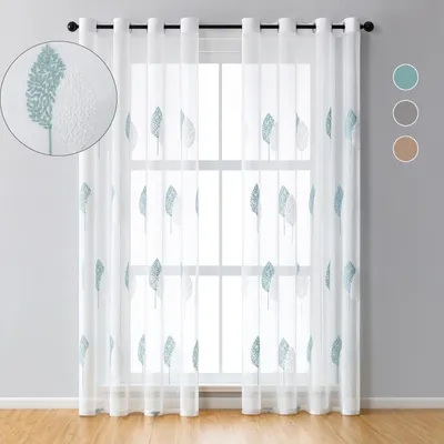A set of sheer curtains with a leaf embroidery pattern hanging on a window.