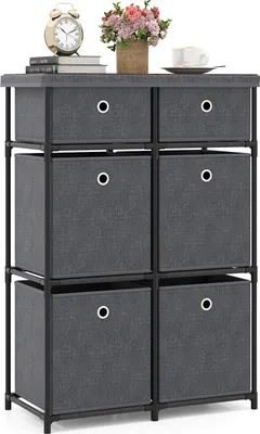 A gray fabric dresser with six drawers and a black metal frame is shown against a white background. On top of the dresser are a clock, some books, a vase of flowers, and a cup of coffee.