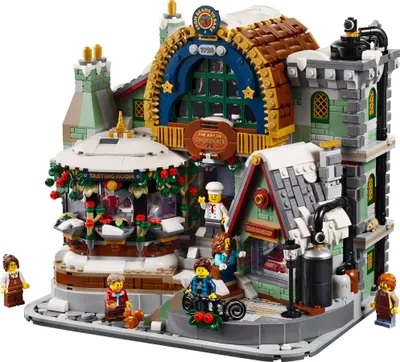 A detailed LEGO model of a chocolate shop with snow and festive decorations.
