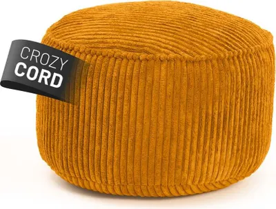 A close-up studio shot of a round, mustard-yellow corduroy pouf.