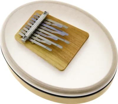 A kalimba musical instrument is placed on a white surface.