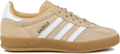 A side view of a tan Adidas Gazelle sneaker with white stripes and a gum sole.