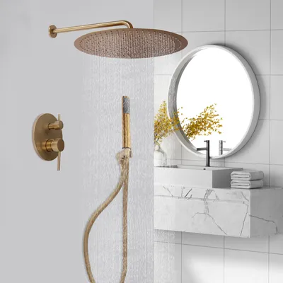 A modern bathroom shower system with a gold finish, including a rainfall showerhead, handheld shower, and control panel, set against a tiled wall and a marble vanity with a round mirror.