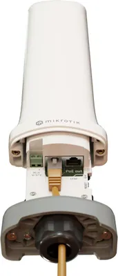 The back view of a white Mikrotik CME Gateway device with cables connected.