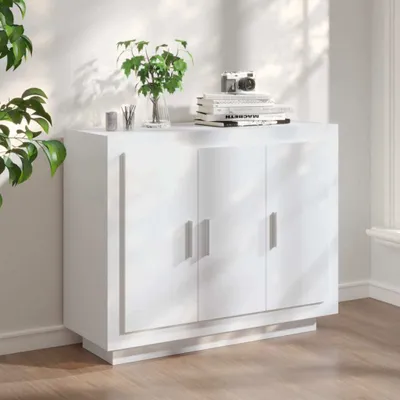 A white sideboard with three doors is shown in a well-lit room with natural light casting shadows.