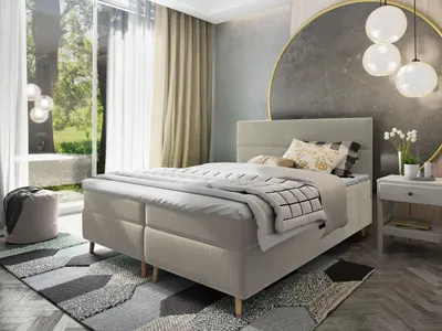 A bedroom scene featuring a boxspring bed, nightstand, and decorative elements.