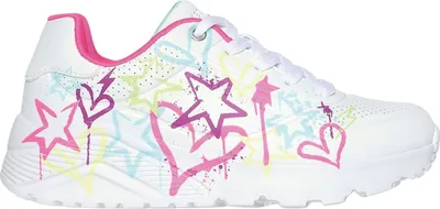 A side view of a white sneaker with colorful graffiti-style stars and hearts.