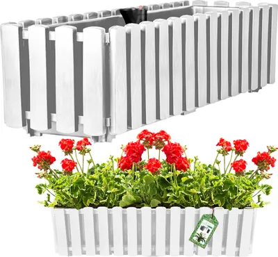 A white planter box with red flowers and green leaves, and a separate white planter box with a black interior.