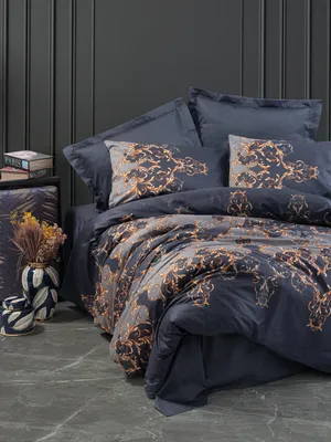 A dark blue satin duvet cover set with a gold damask pattern is displayed on a bed.