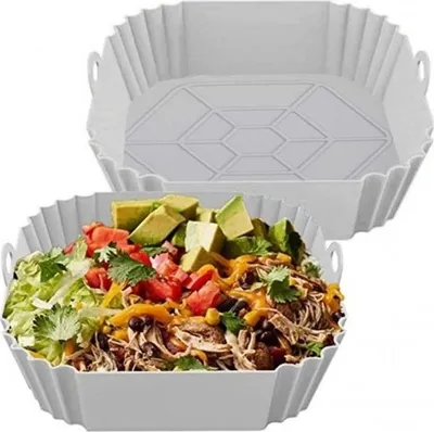 A reusable silicone liner for an air fryer, shown both empty and filled with food.