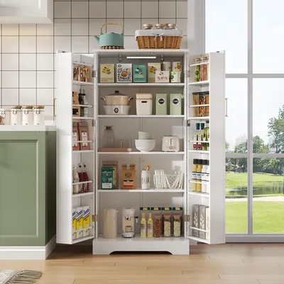 A white kitchen cabinet filled with various food items and kitchenware, positioned in a kitchen setting with a window view of greenery in the background.