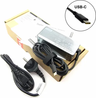 A Lenovo laptop charger and its accessories are laid out on a white surface, with the product packaging partially visible.