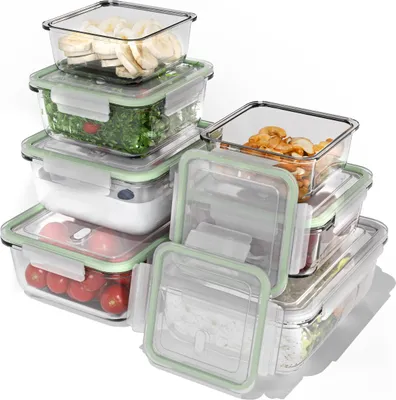 A collection of glass food storage containers with green lids, stacked and arranged.
