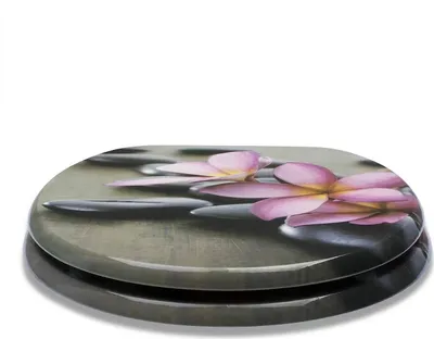 A toilet seat with a printed design of spa stones and pink flowers.