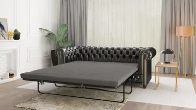 A Chesterfield sofa is shown in a living room setting, with the bed mechanism extended.