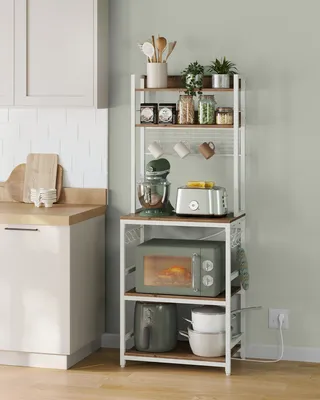 A kitchen scene with a baker's rack filled with kitchen appliances and accessories.