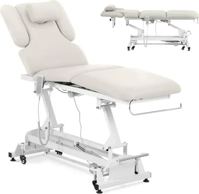 A white electric massage table with beige upholstery is shown against a white background. A smaller, identical table is visible in the upper right corner.