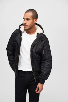 A man wearing a black hooded jacket and a white t-shirt, posing against a white background.