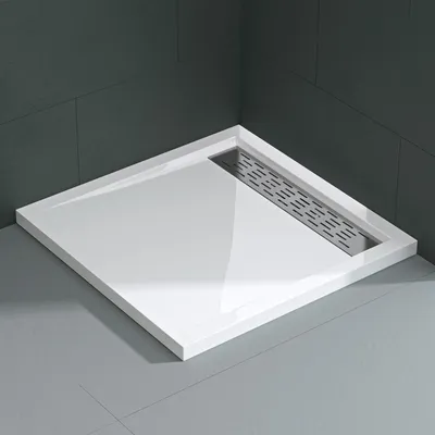 A white shower tray with a silver drain is shown in a corner of a bathroom with dark gray tiled walls and a light gray tiled floor.