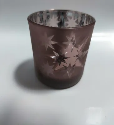 Ein kleines, zylindrisches Glas, das mit einem mattierten, bräunlichen Farbton versehen ist.