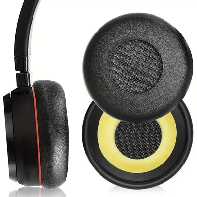 A side view of a black headphone earcup and two replacement earpads, one with a yellow inner cushion.