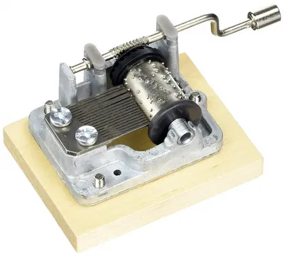 A music box mechanism mounted on a wooden base, isolated on a white background.
