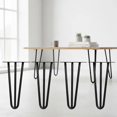 Four black hairpin legs are displayed in the foreground, with a wooden table and a mug on it in the background.