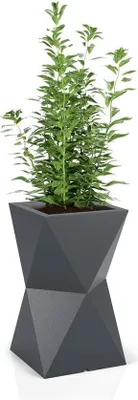 A tall, dark gray geometric planter with a green plant growing out of it, set against a white background.