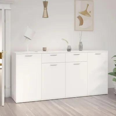 A white sideboard with drawers and doors in a room with a white wall and wooden floor.
