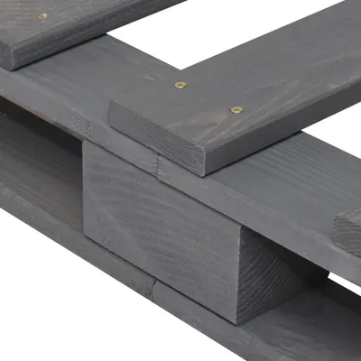 A close-up view of the corner of a wooden pallet bed frame, showing the construction details.