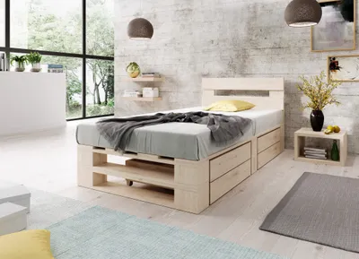 A bedroom scene with a wooden bed frame, bedding, and decor.