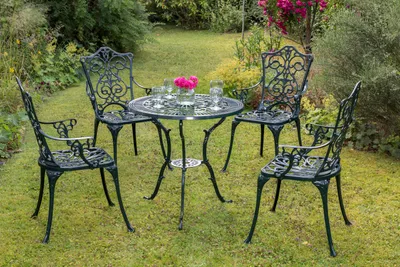 A garden table and four chairs set in a garden setting.